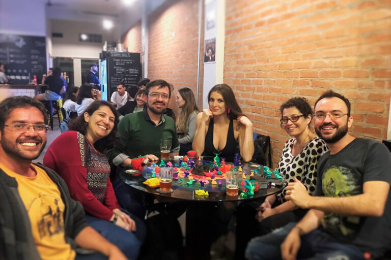 Grupo de jogadores em uma Terça Nerd reunido ao redor do tabuleiro do Planeta Insano