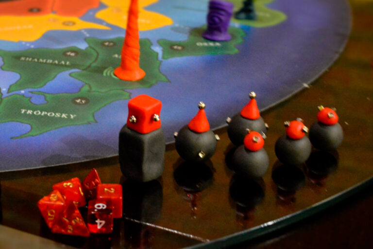 Criaturas do jogo de tabuleiro Planeta Insano alinhadas próximas ao tabuleiro durante uma Terça Nerd